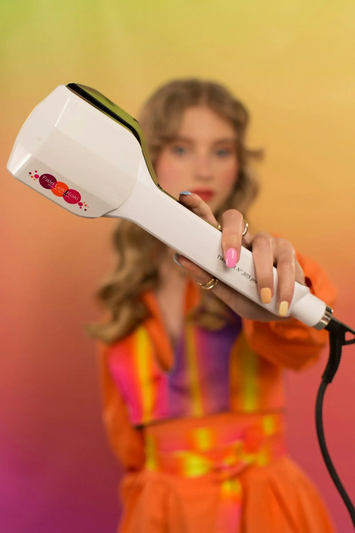 Woman holding a curling iron, choosing the right barrel size